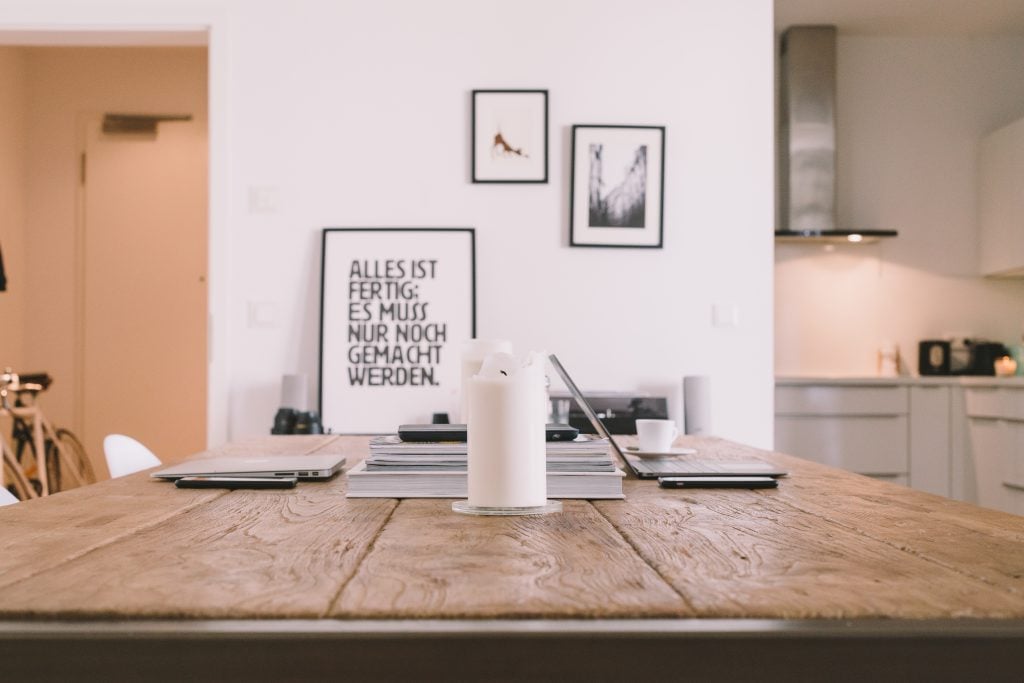 table setup with candle, books, laptops