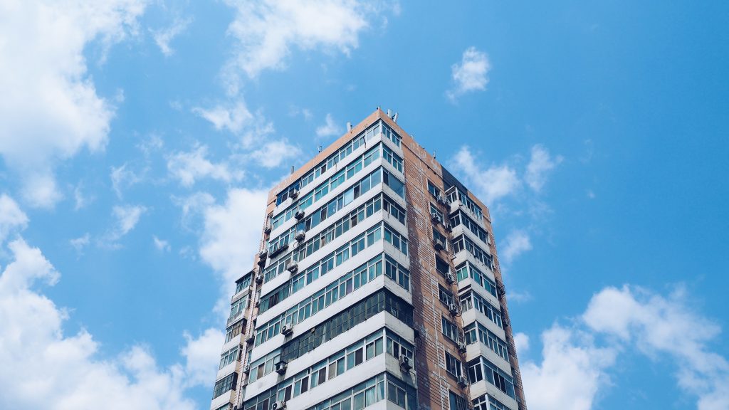 upward view of high rise condo against blue sky 