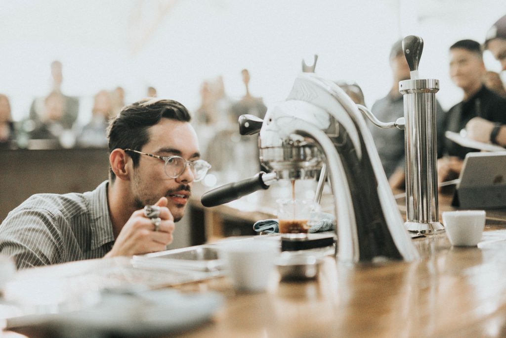 man making coffee drink at bar