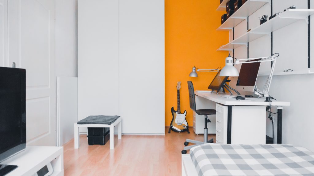 modern bachelor style apartment with orange accent wall